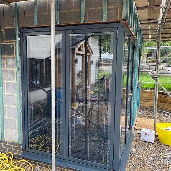 Floating corner post in a set of Origin bi-folding doors with integral blinds in Anthracite Grey - Oxfordshire